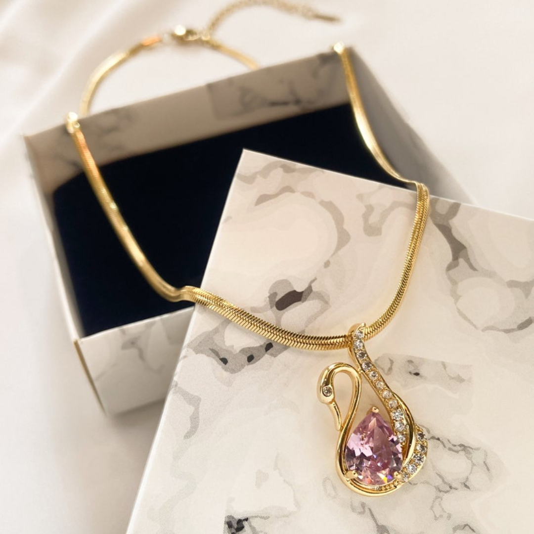Elegant gold swan-shaped pendant with purple gemstone