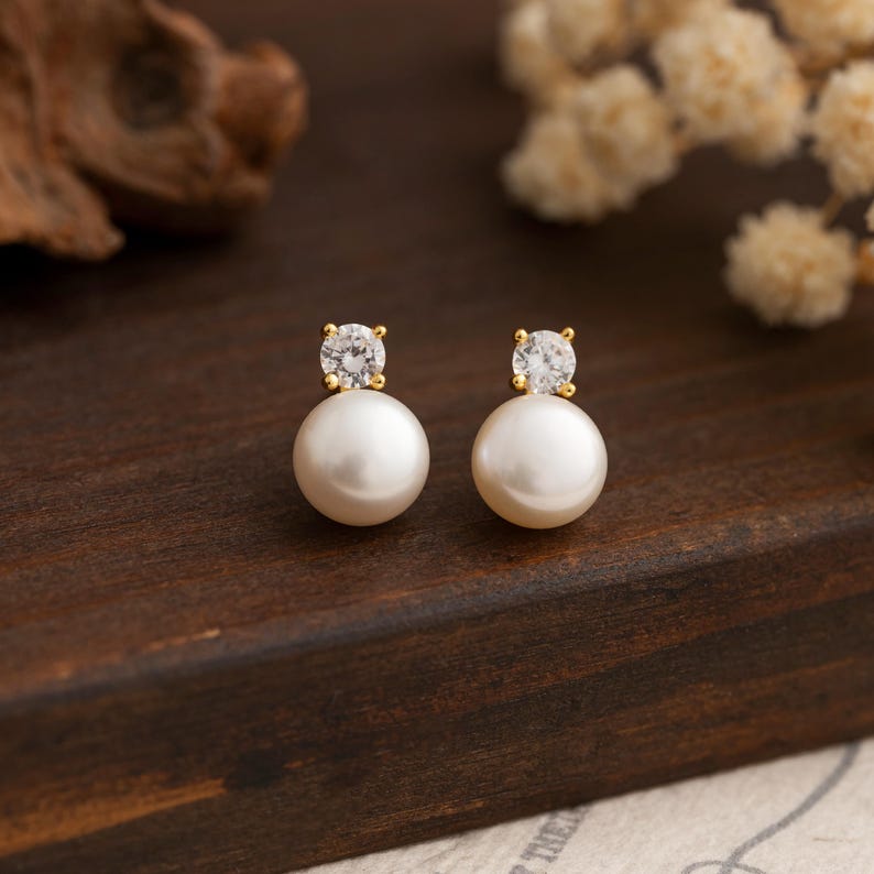 Gold stud earrings featuring pearls and crystals